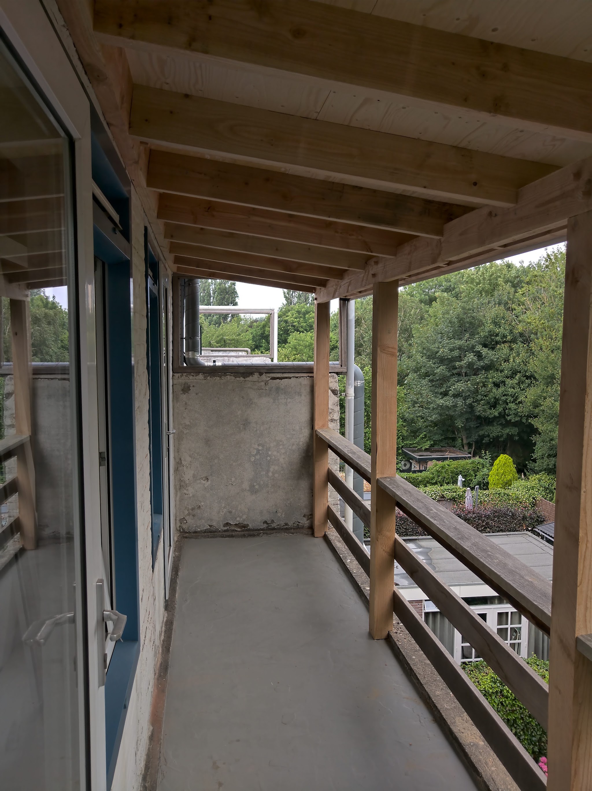 Binnenzijde van een houten veranda met uitzicht over de tuin