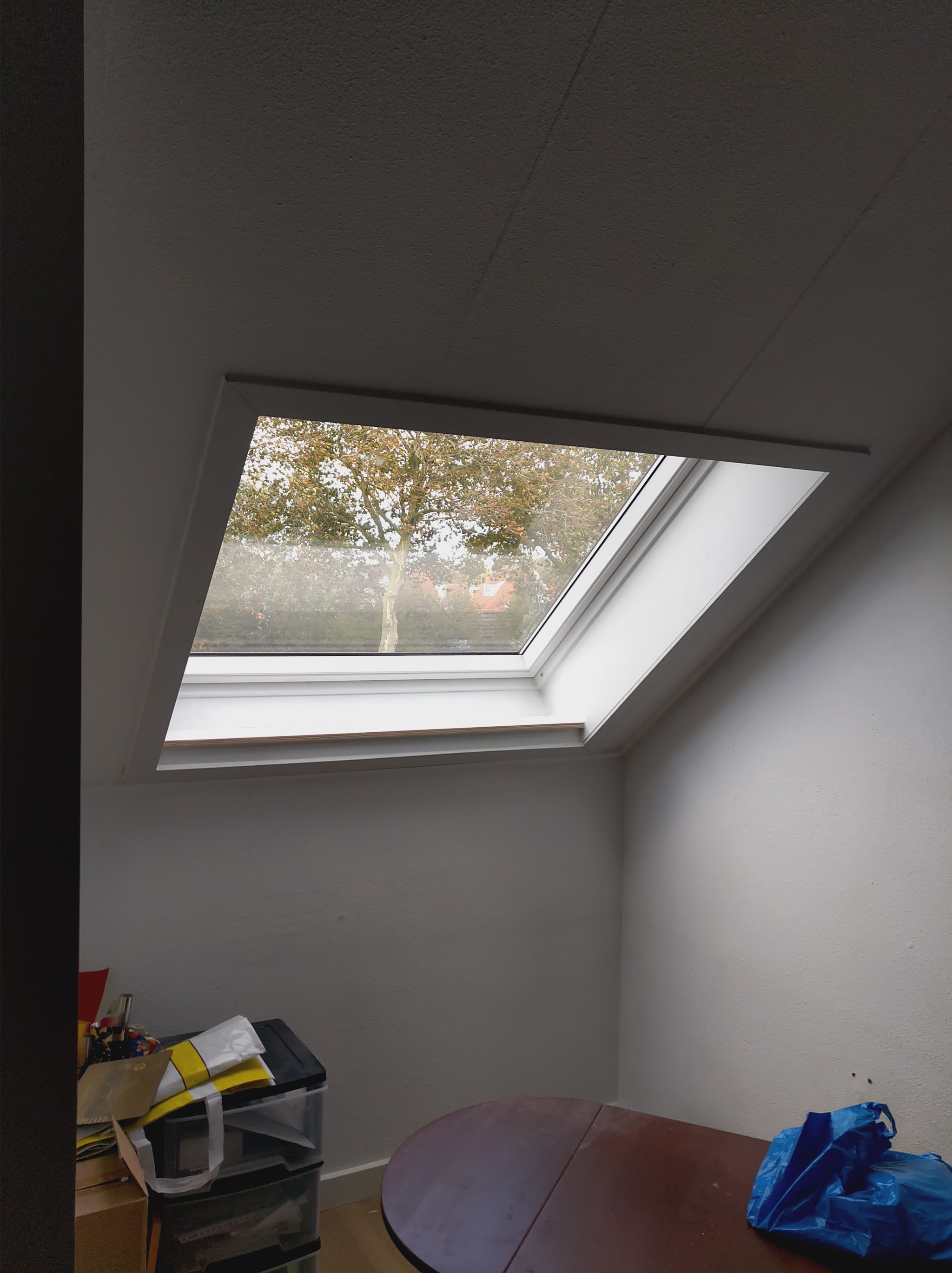 Nieuw geplaatst dakraam in een schuin dak, netjes afgewerkt